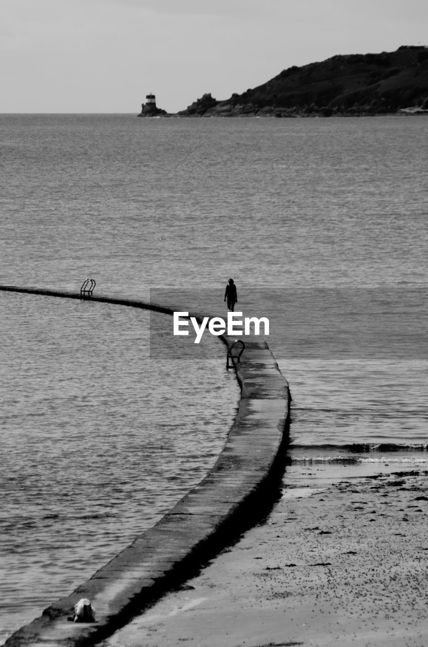 Person walking along groyne