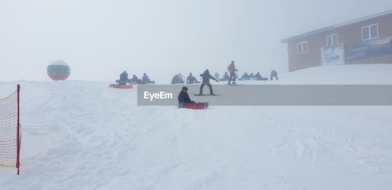 PEOPLE WALKING ON SNOW COVERED FIELD