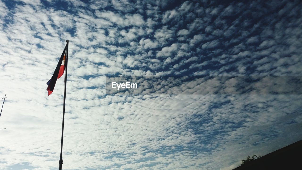 LOW ANGLE VIEW OF FLAG AGAINST CLOUDY SKY