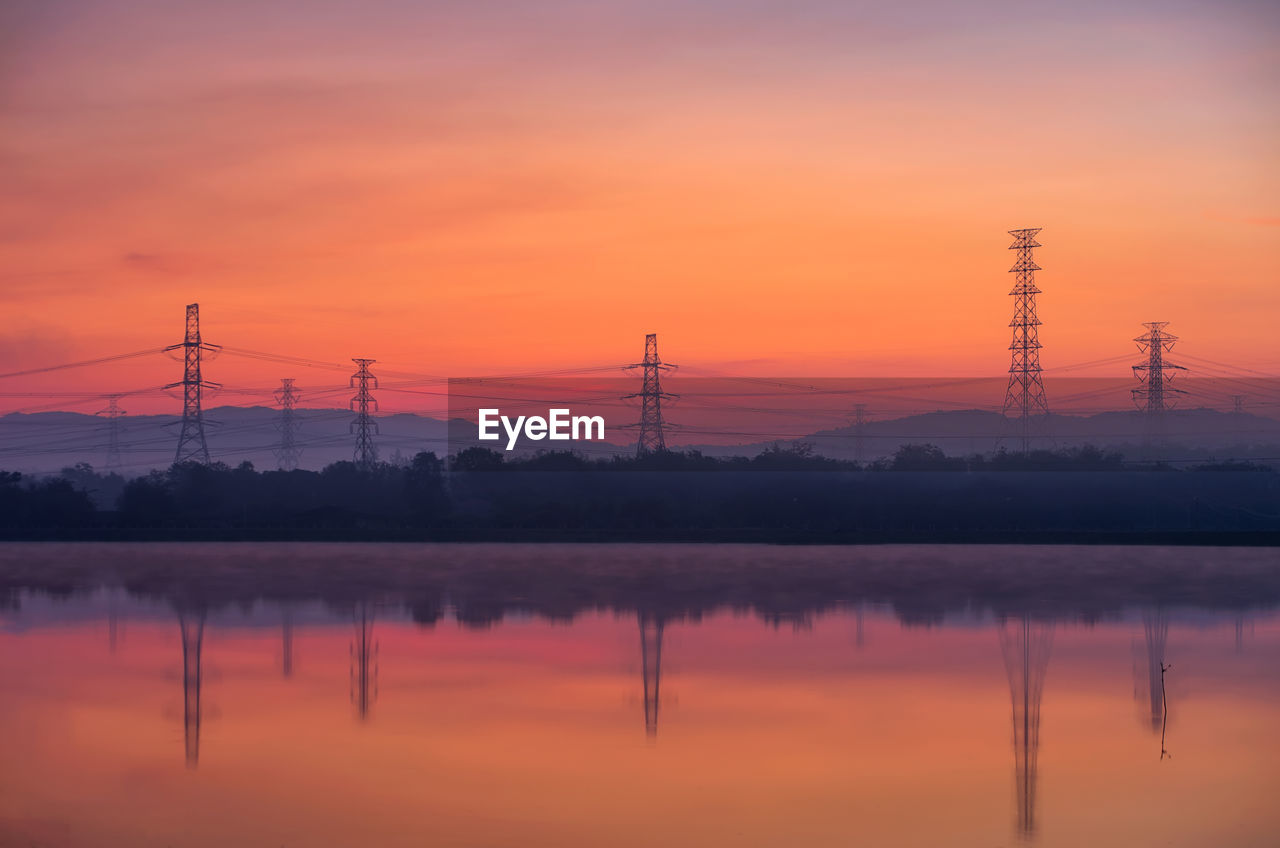 Electricity pylon or high-voltage transmission towers on the hill with reflection. 