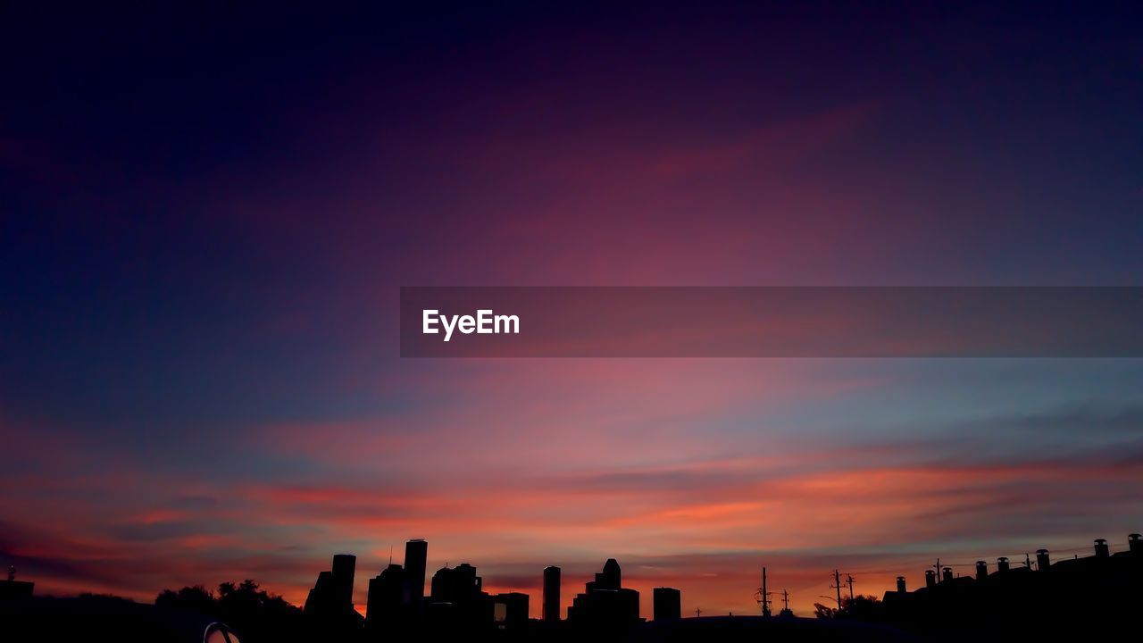 SILHOUETTE CITY AGAINST SKY AT SUNSET