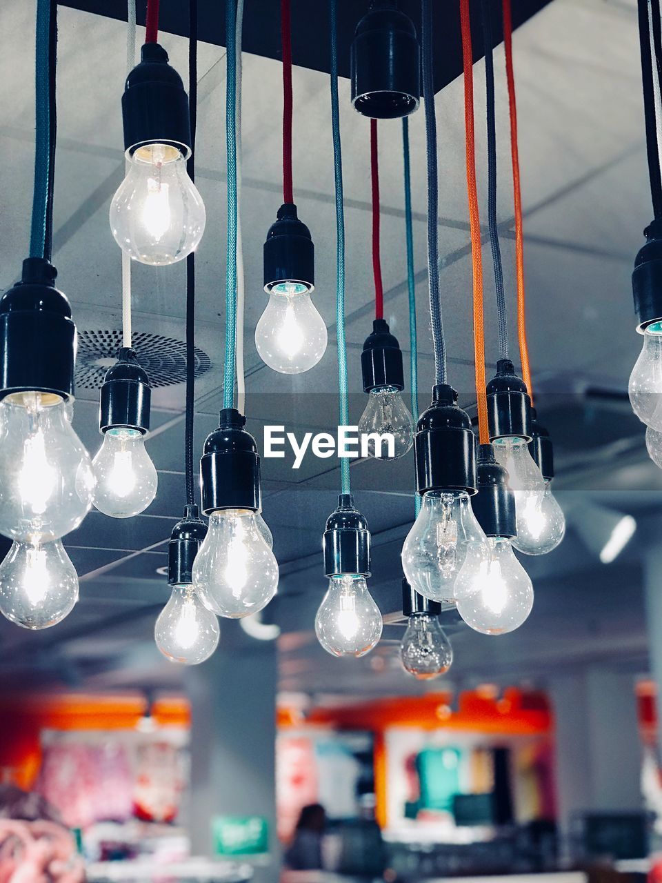 Low angle view of illuminated pendant light hanging from ceiling