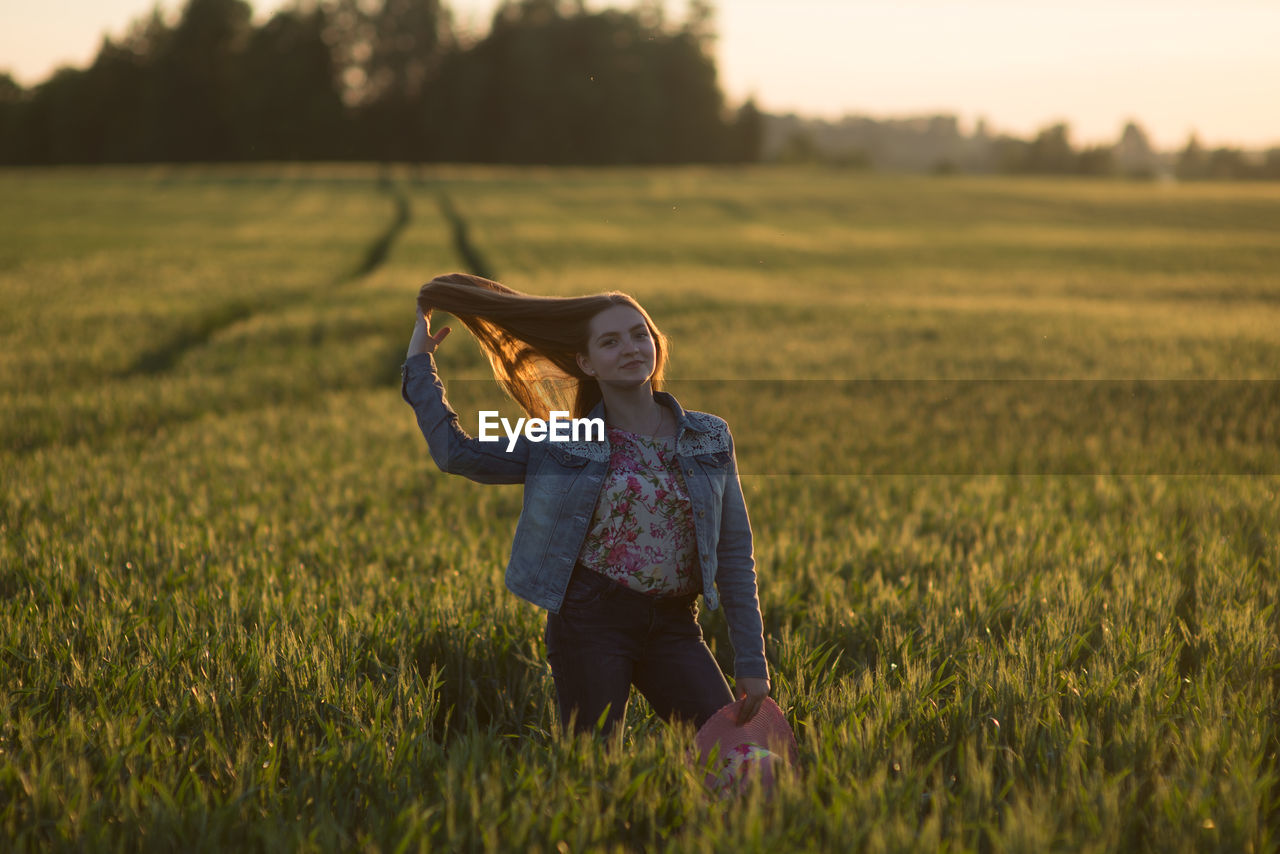 Portrait of woman standing on field