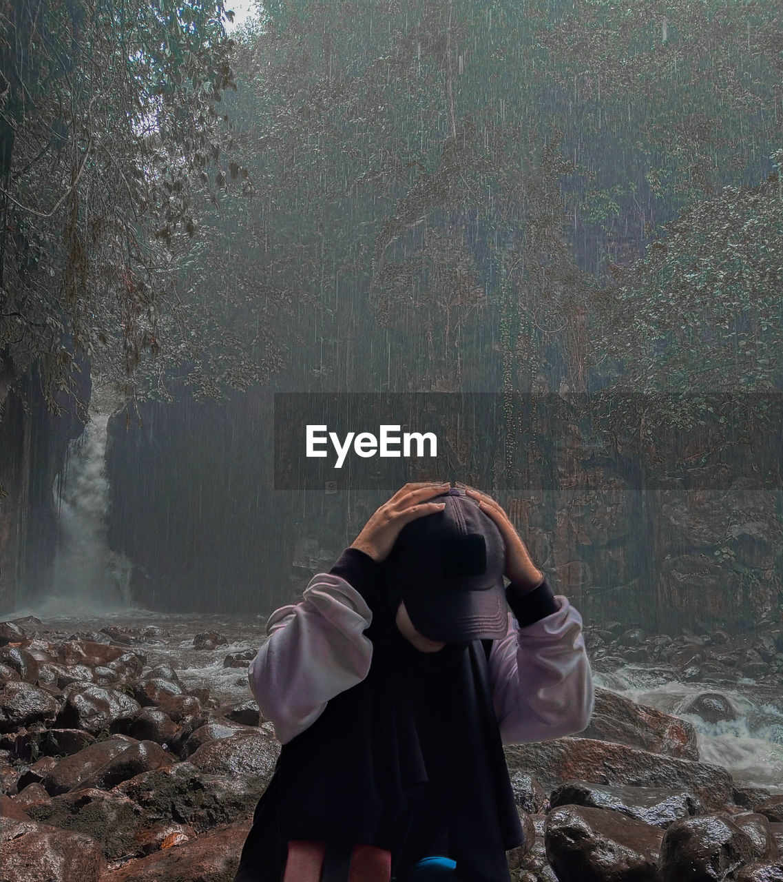 Rear view of woman standing against trees in forest