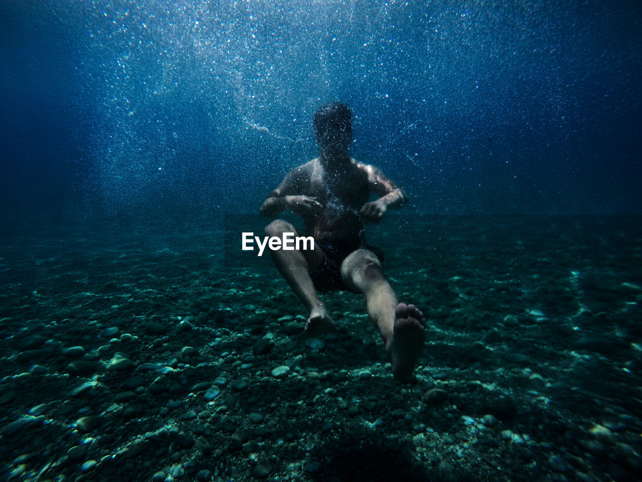 Full length of shirtless man swimming in sea