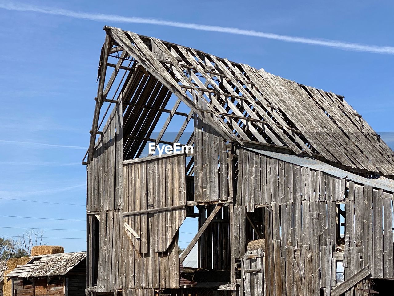 Low angle view of abandoned barn against sky