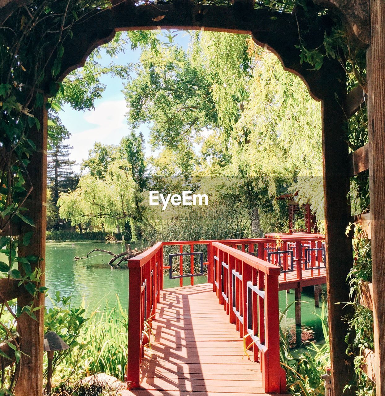 Wooden walkway over lake seen through gazebo
