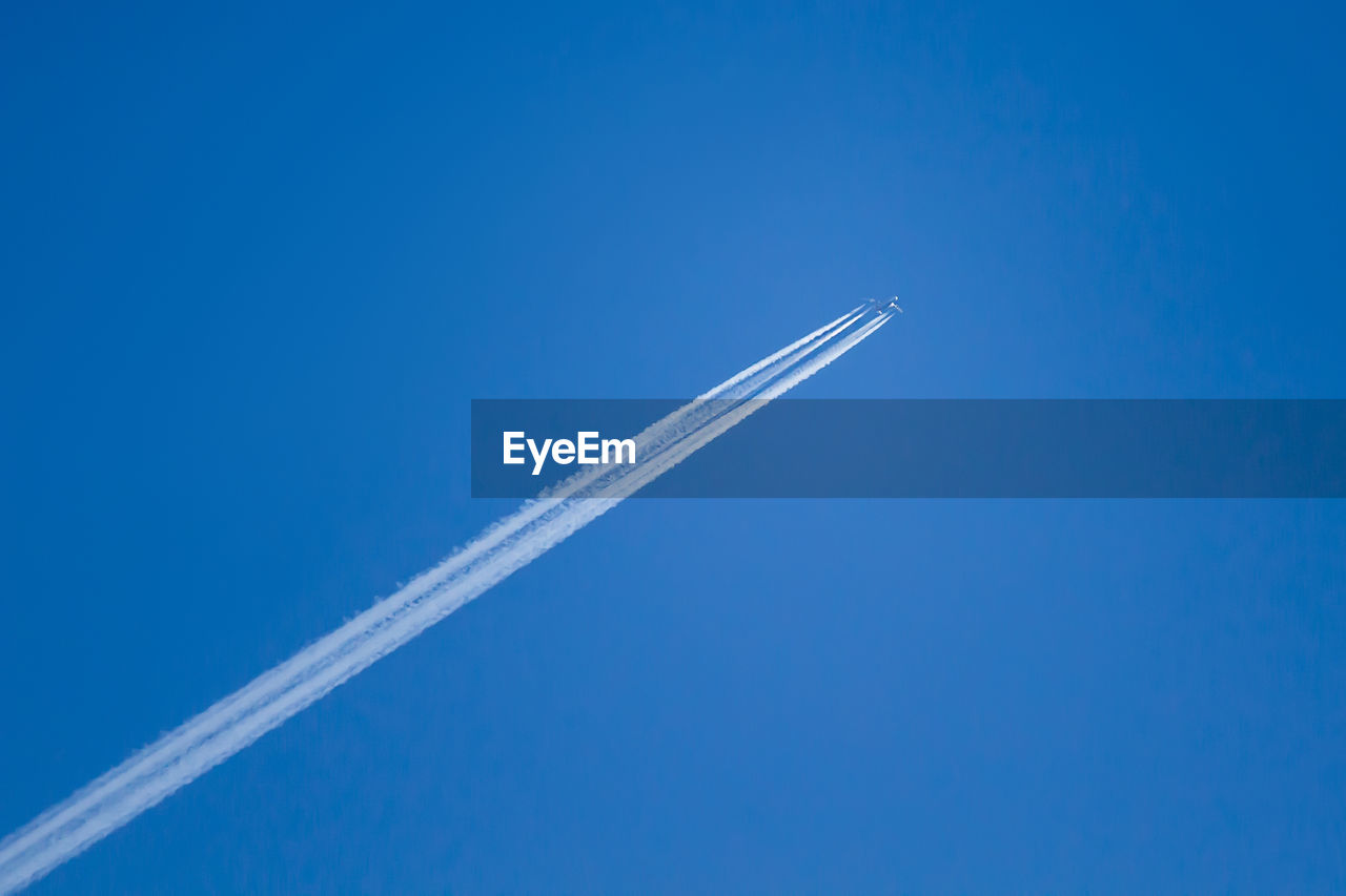 White trail from an airplane in the blue sky
