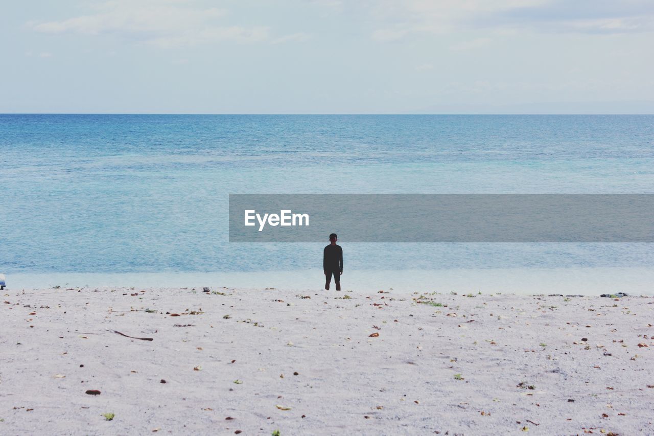 REAR VIEW OF MAN ON BEACH