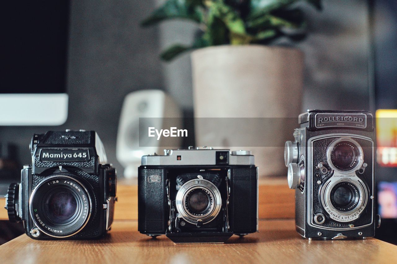 CLOSE-UP OF CAMERA ON TABLE WITH EYEGLASSES