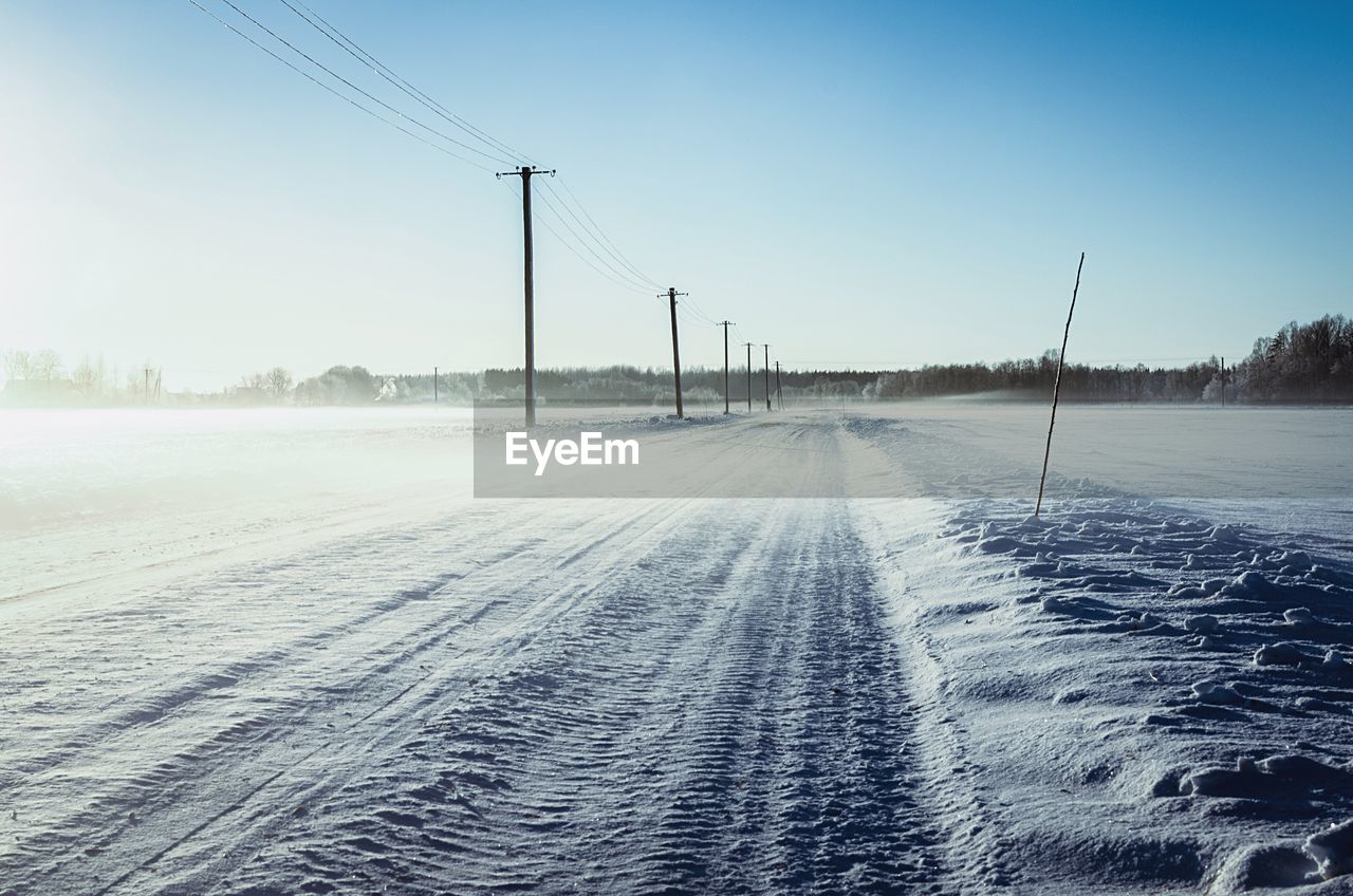 Snow covered road against clear sky