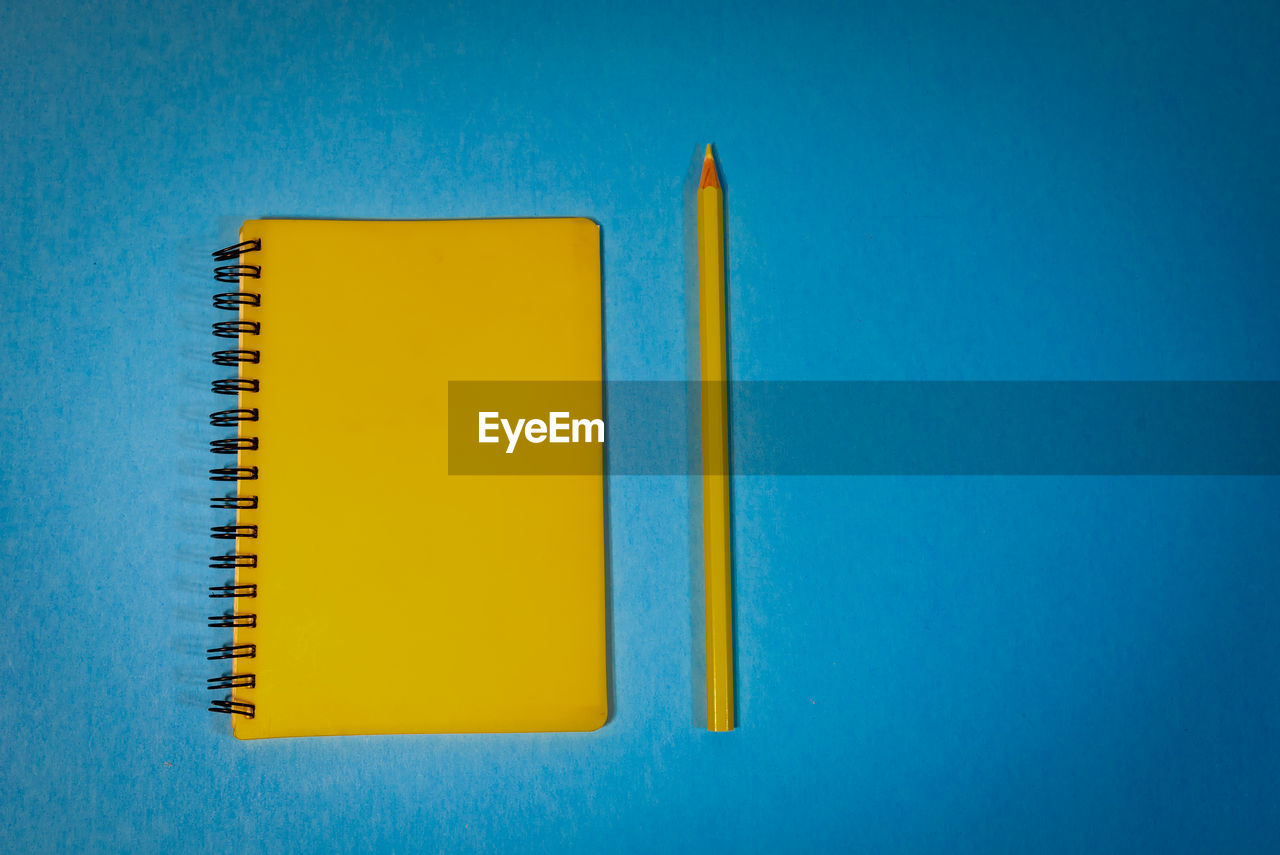 High angle view of yellow book against blue background