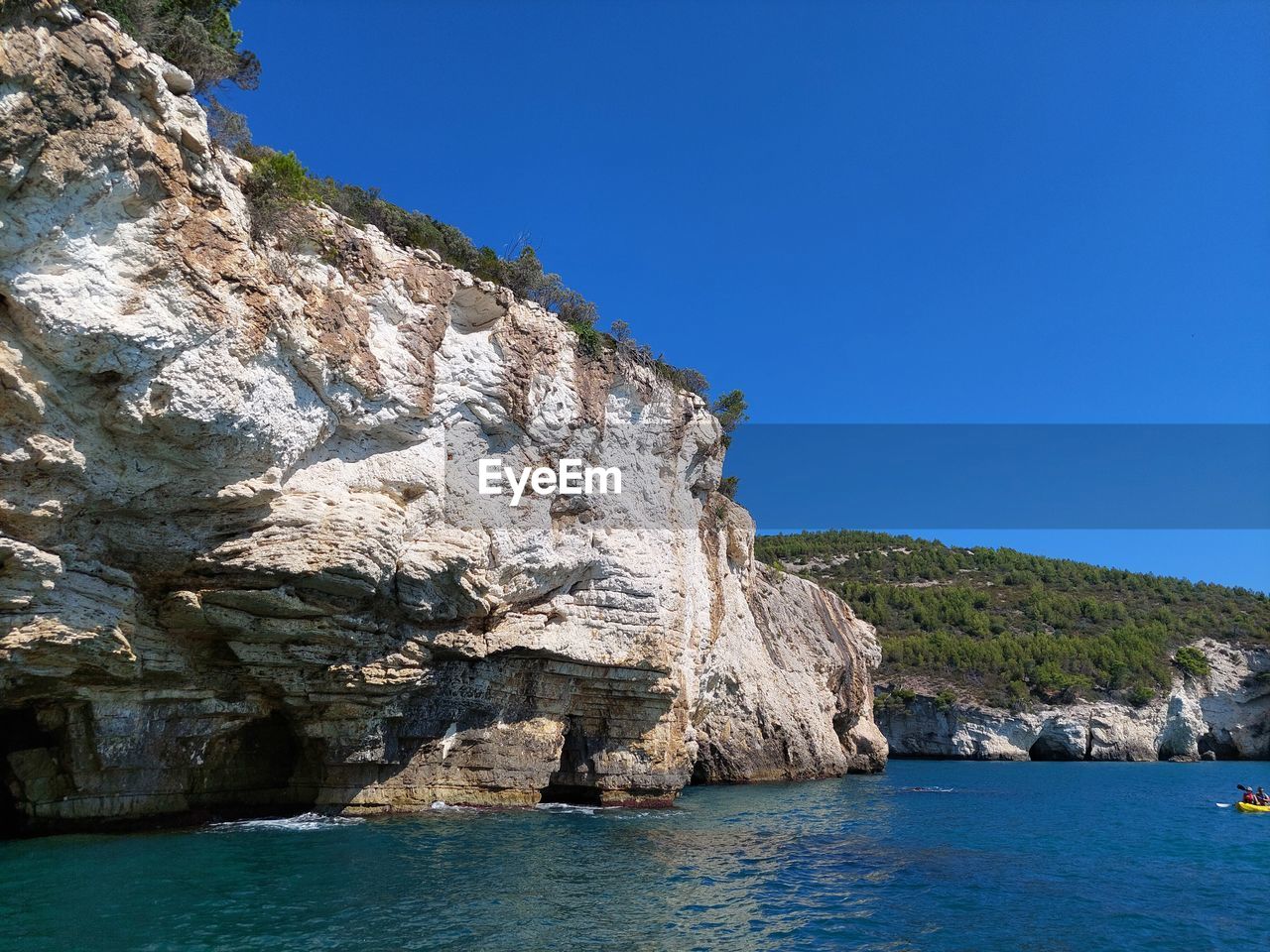 ROCK FORMATION IN SEA AGAINST CLEAR SKY