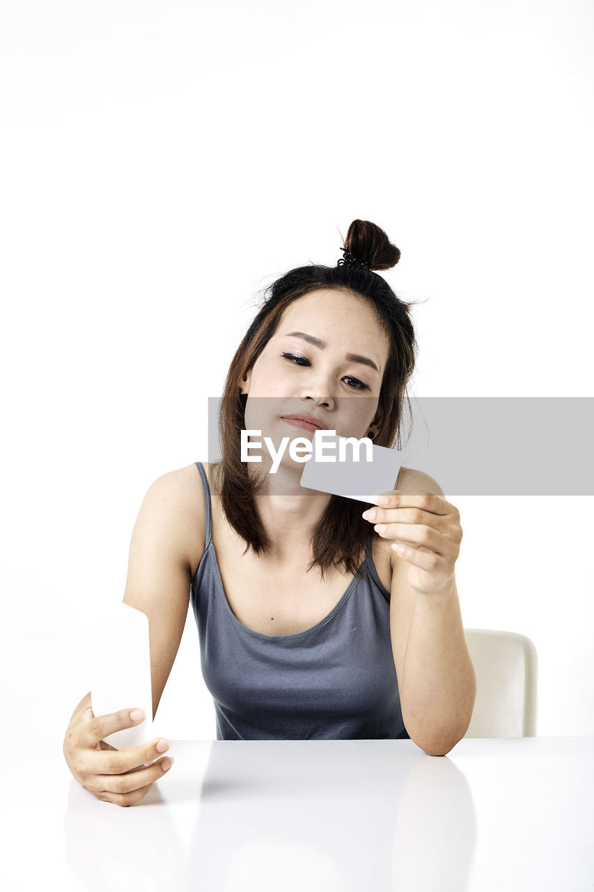 PORTRAIT OF YOUNG WOMAN HOLDING MOBILE PHONE