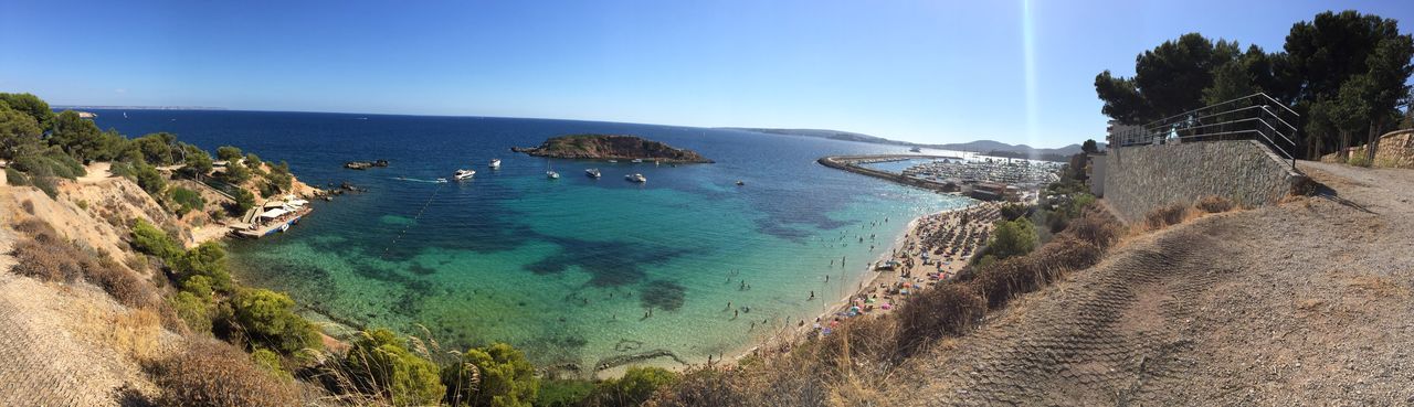 Panoramic view of beach against clear blue sky