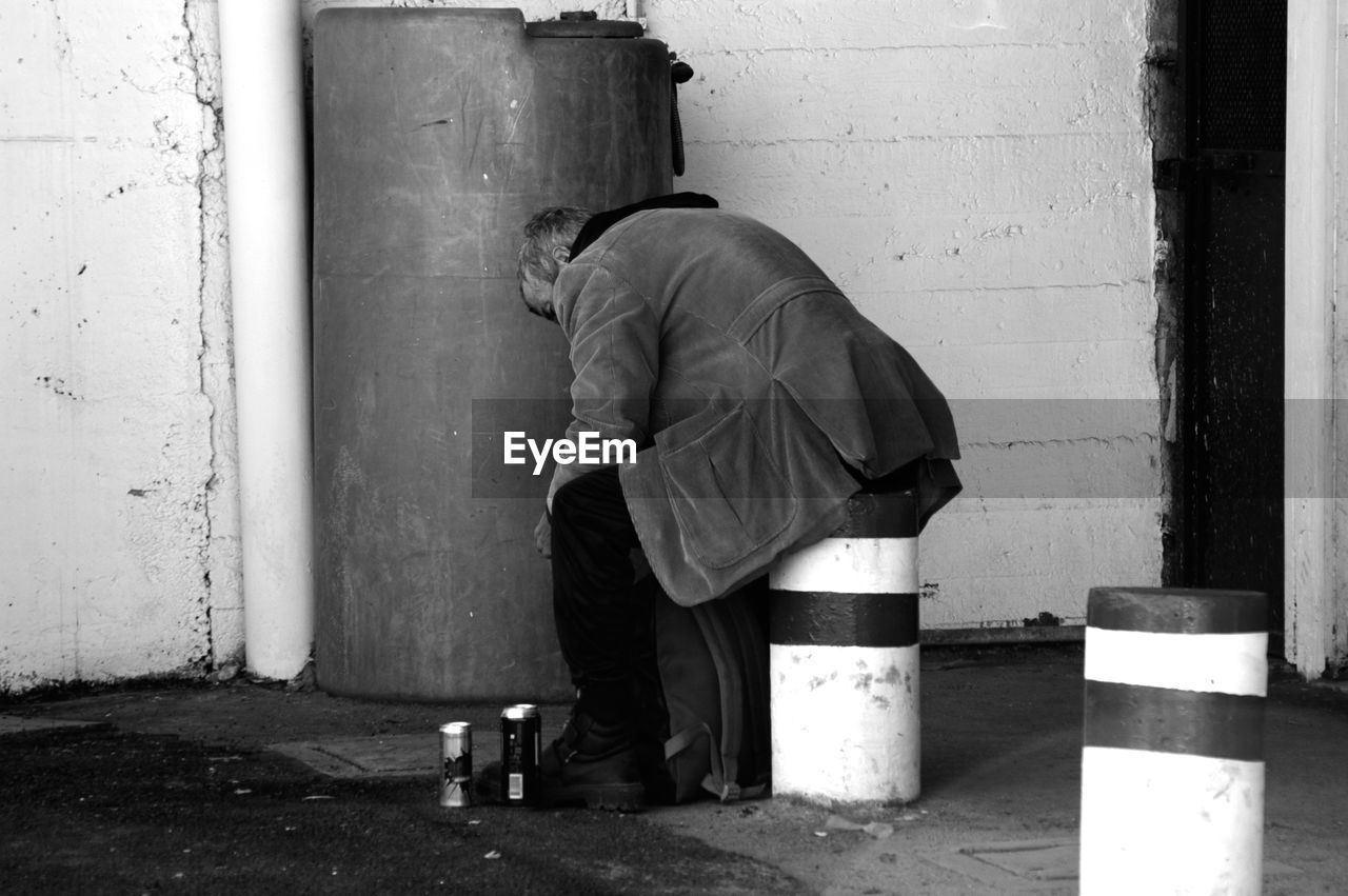 Homeless man sitting on footpath