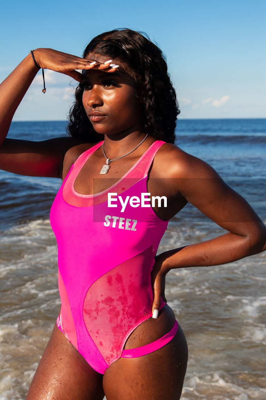 MID ADULT WOMAN AT BEACH DURING SUNSET