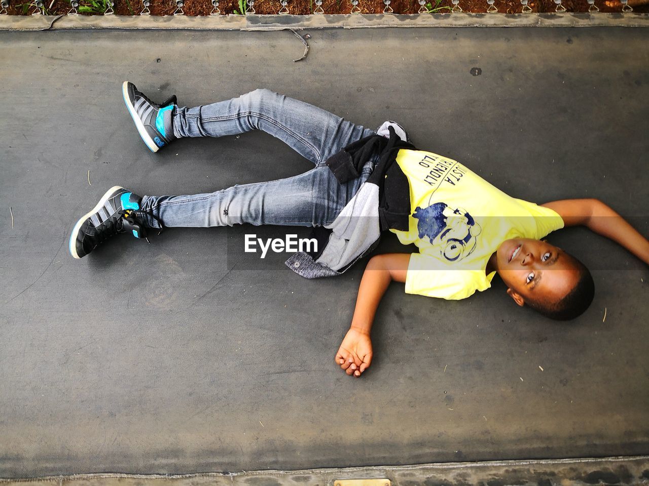 HIGH ANGLE VIEW OF YOUNG MAN LYING ON FLOOR