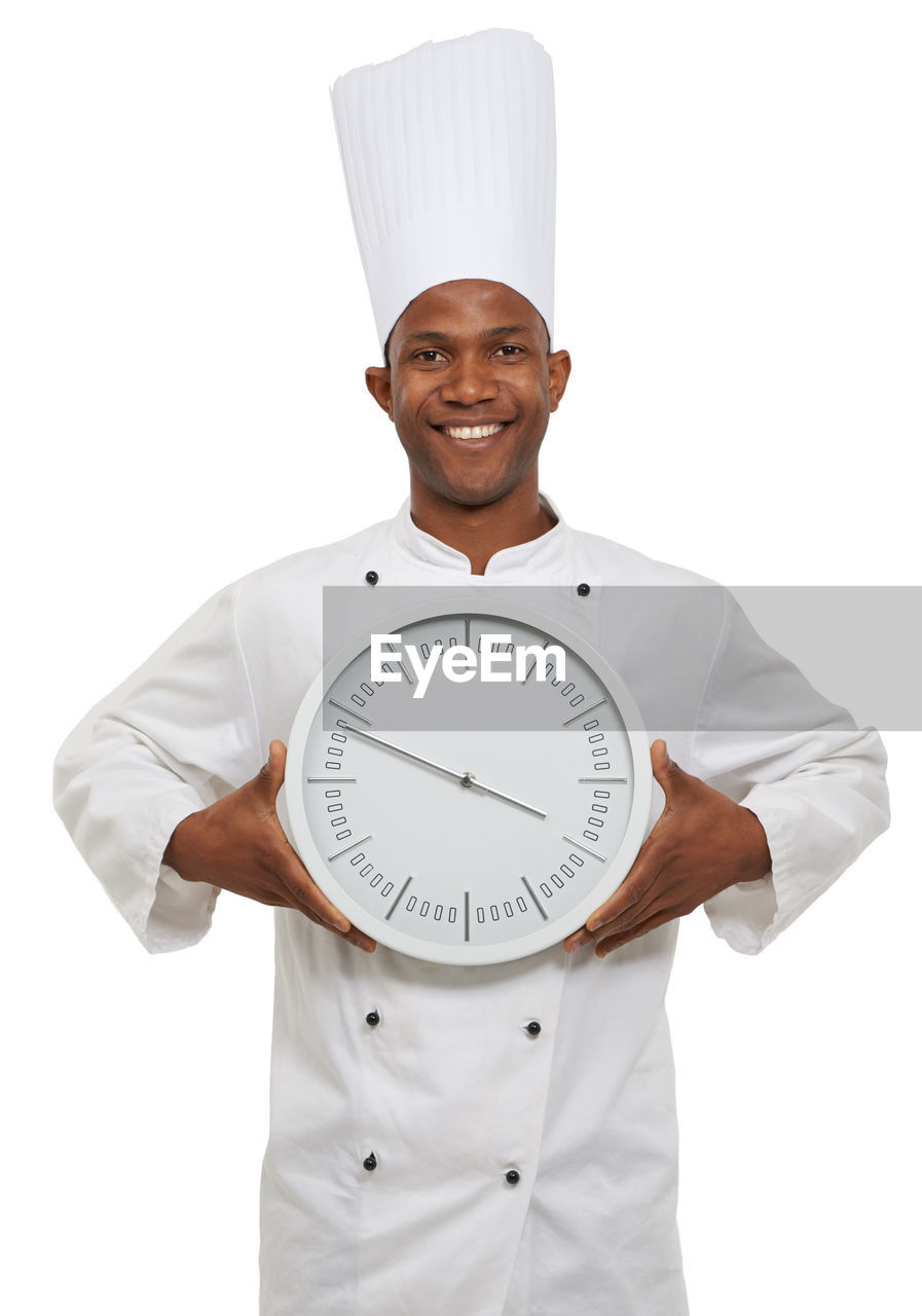 cook, white background, cut out, portrait, adult, clock, men, studio shot, one person, looking at camera, occupation, smiling, standing, uniform, indoors, emotion, white, clothing, chef, front view, happiness, hand, person, waist up, chef's hat, business, holding, working