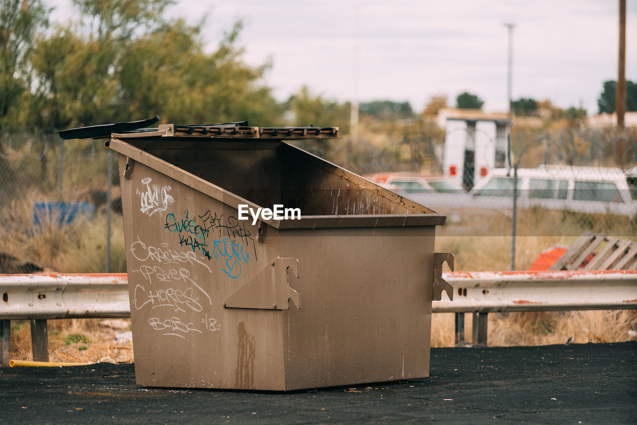 CLOSE-UP OF GARBAGE BIN AGAINST BUILT STRUCTURES