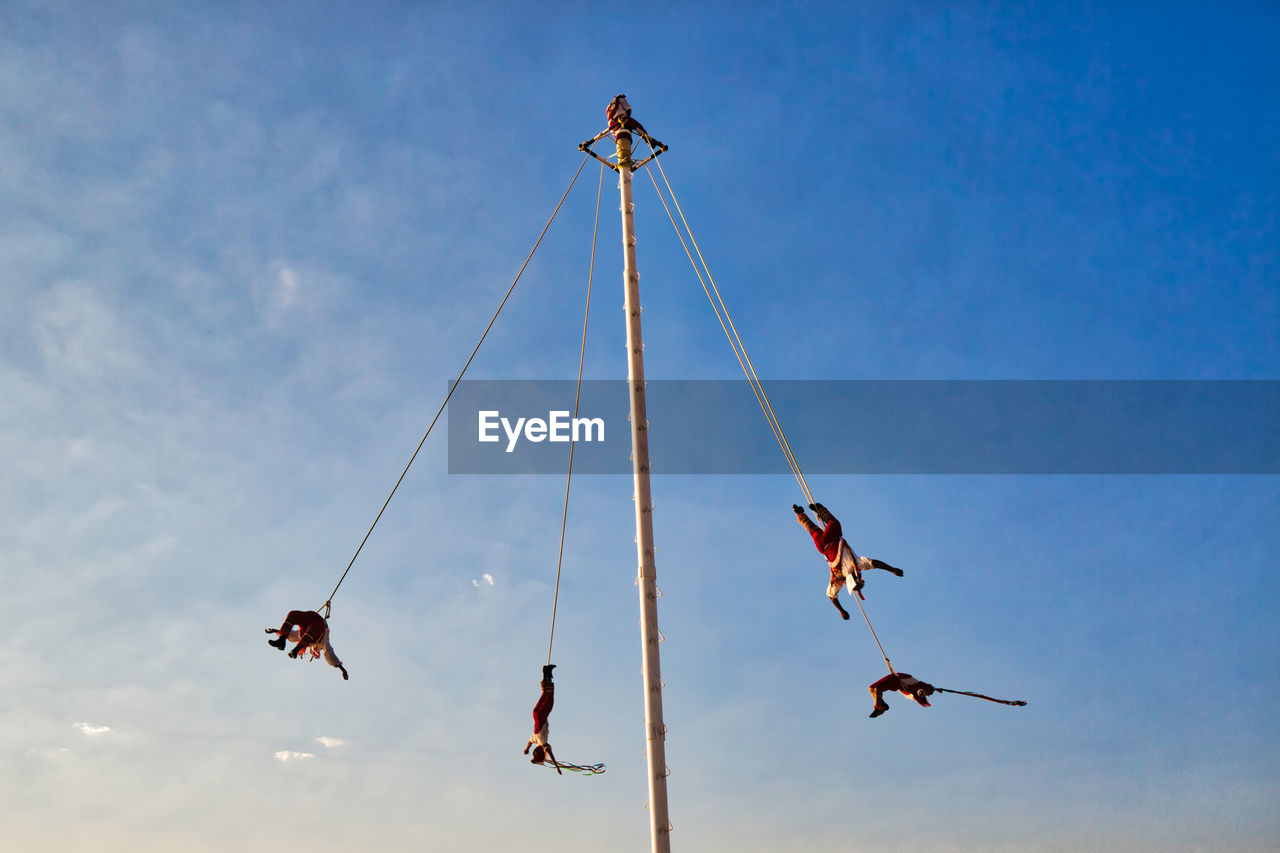 LOW ANGLE VIEW OF HELICOPTER HANGING ON ROPE