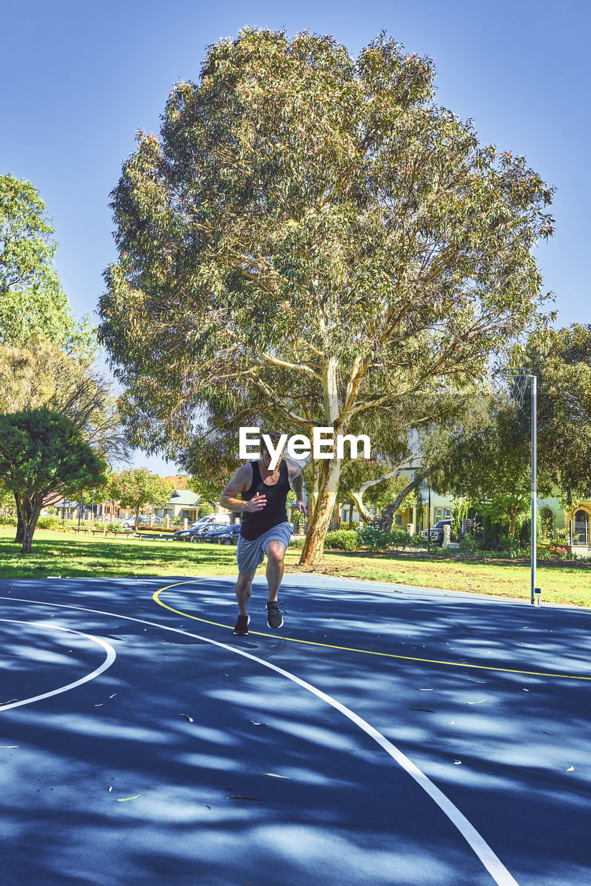 Young man running on road while exercising at park