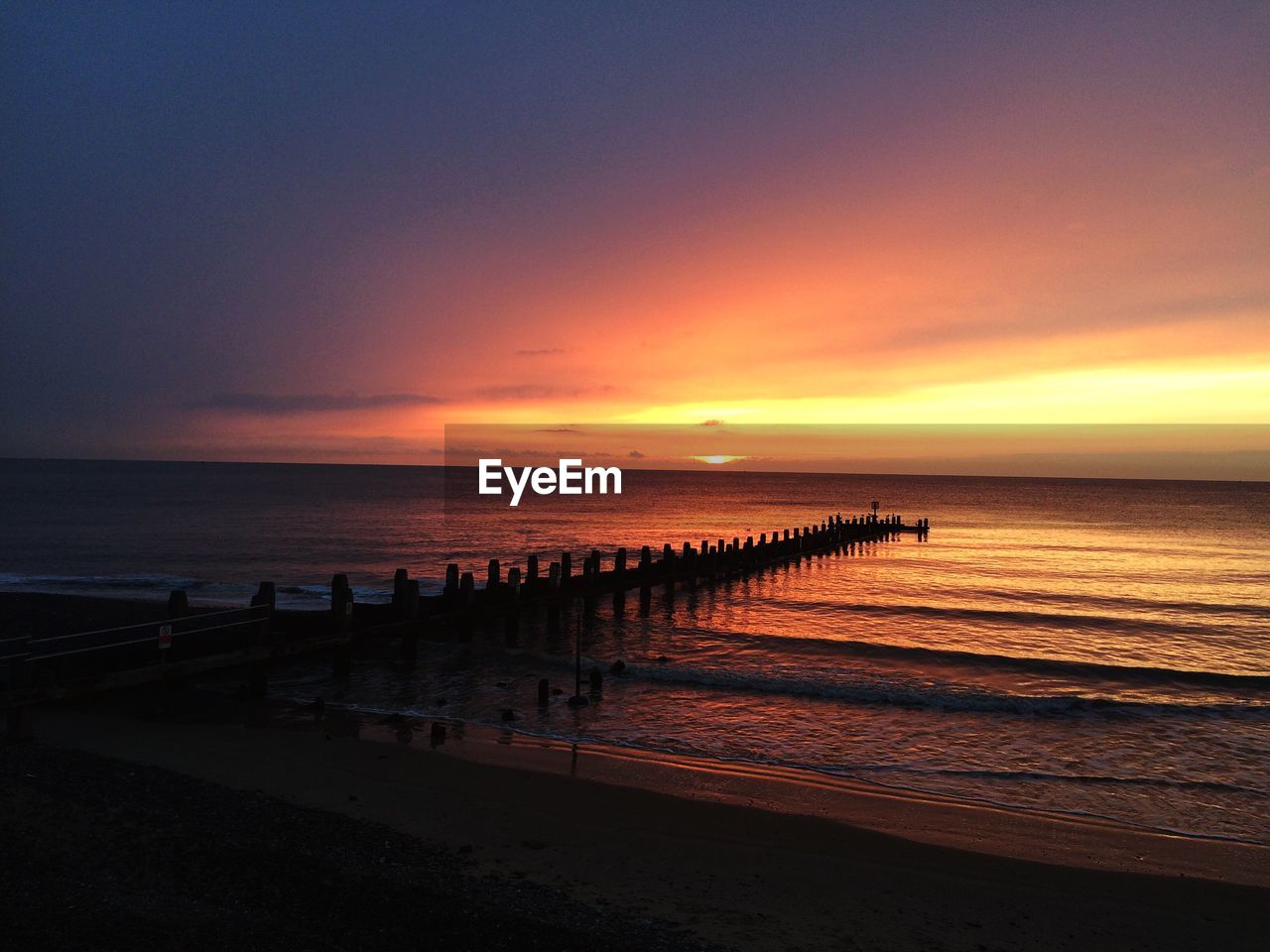 Scenic view of beach against cloudy sky