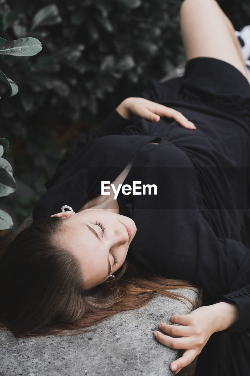 High angle view of woman lying on land by plants