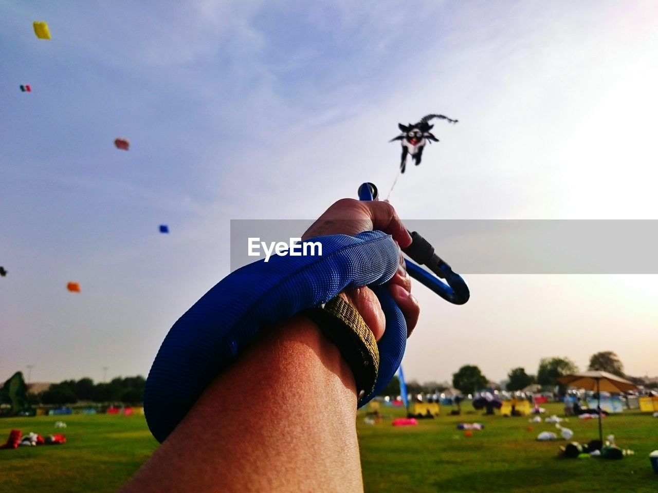 LOW ANGLE VIEW OF WOMAN FLYING KITE