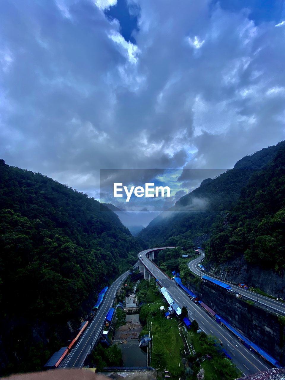 high angle view of road amidst mountains against sky