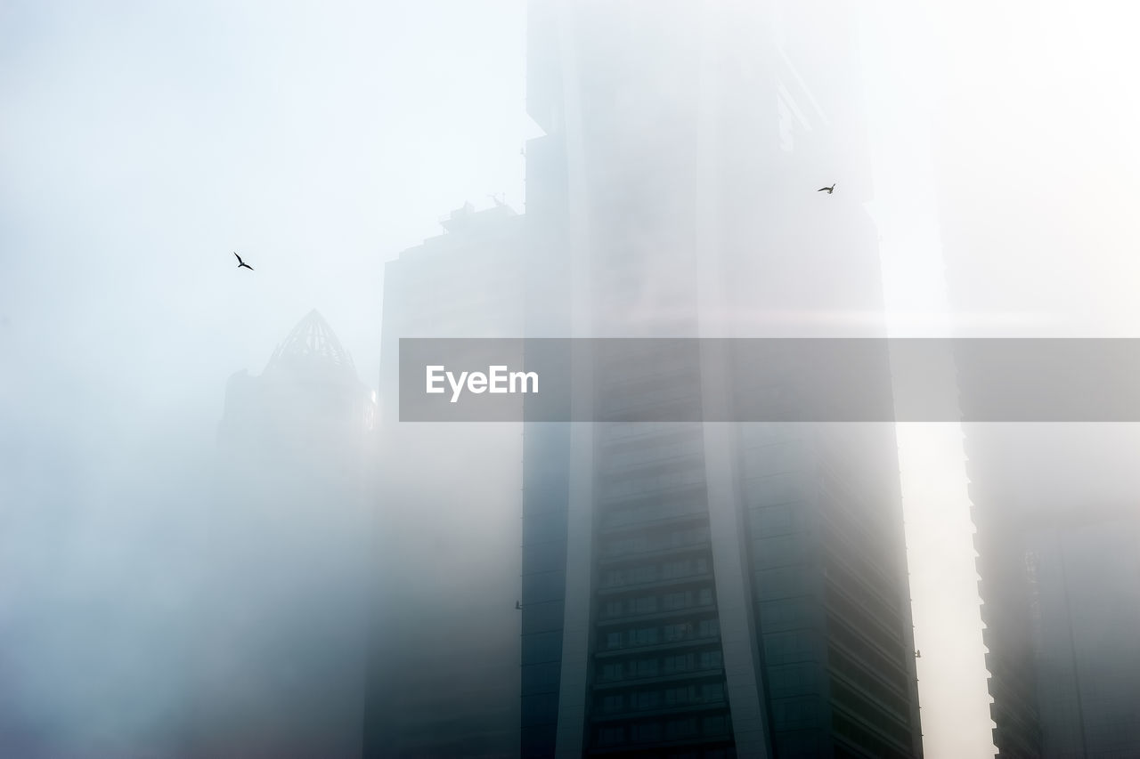 Low angle view of building amidst fog in city