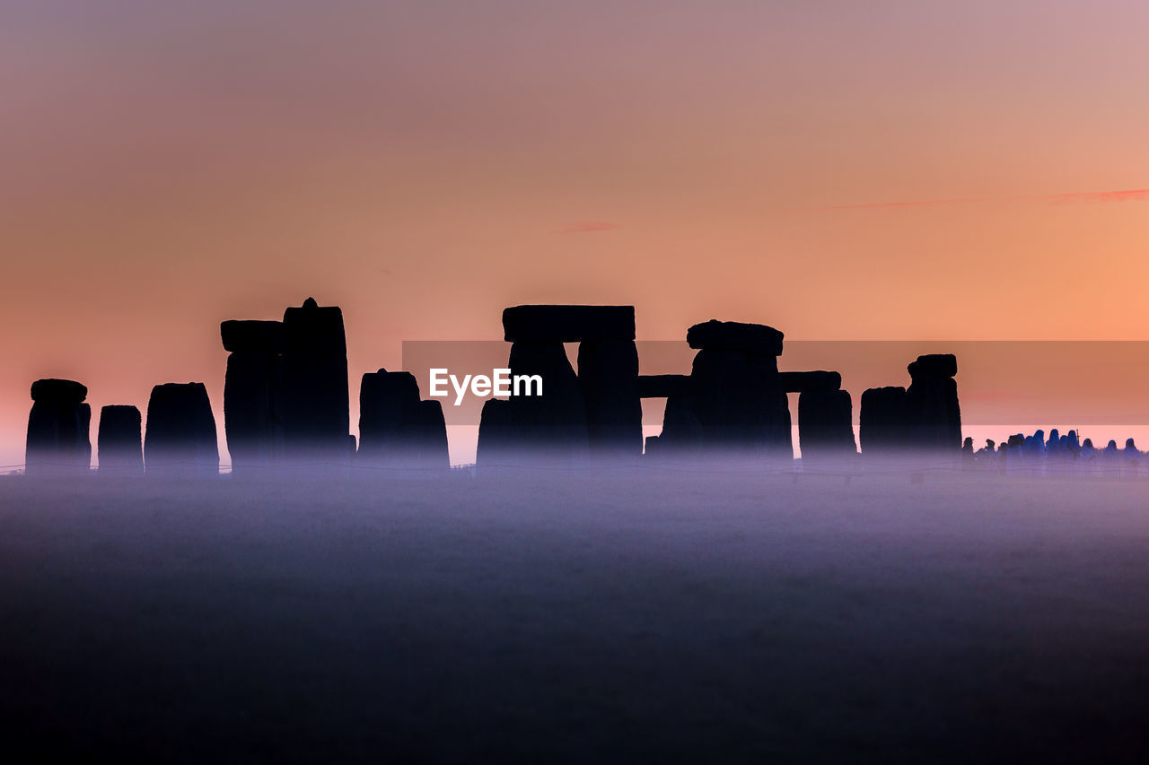 Scenic view of silhouette rock formation against sky during sunset