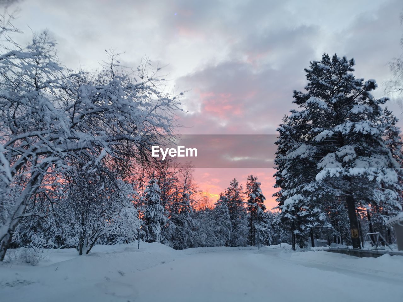 SNOW COVERED FIELD AGAINST SKY DURING SUNSET