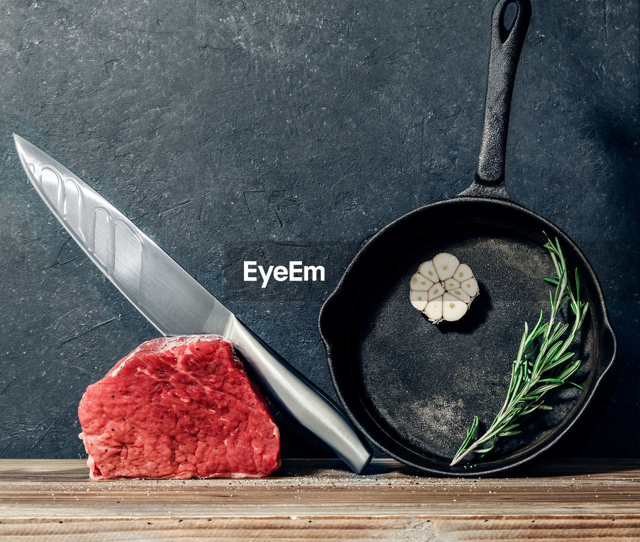 Close-up of meat with table knife and frying pan