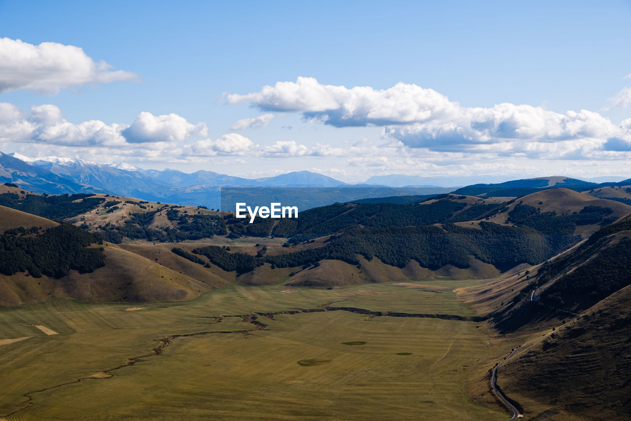 Scenic view of field and mountains against sky in castelluccio, umbria italy