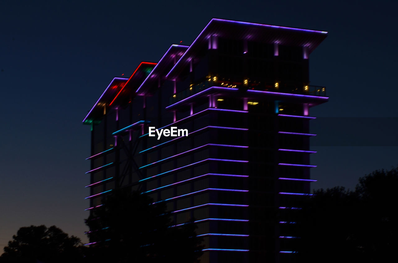 LOW ANGLE VIEW OF ILLUMINATED BUILDING AGAINST CLEAR SKY