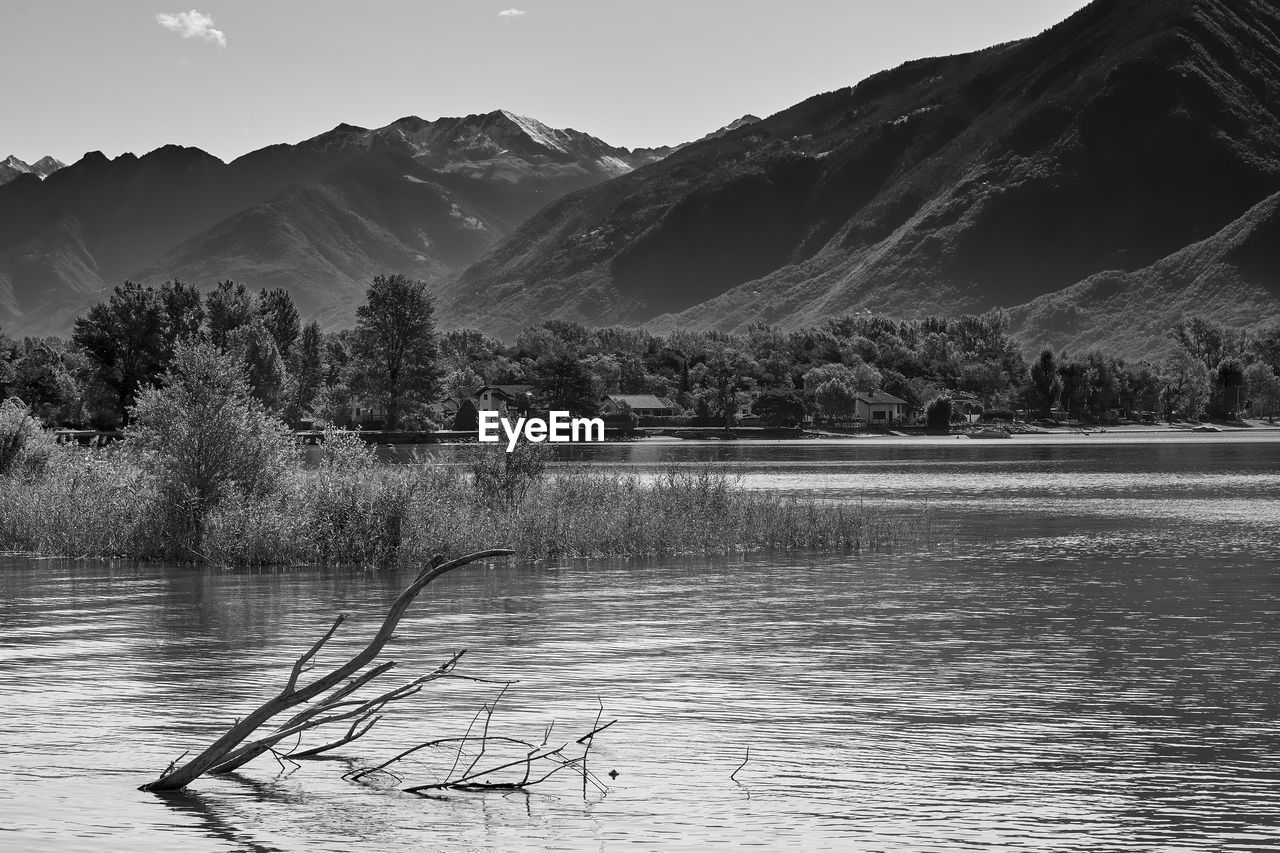 Scenic view of lake by mountains against sky