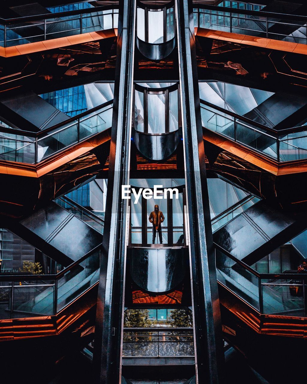 LOW ANGLE VIEW OF MAN STANDING ON STAIRCASE OF BUILDING