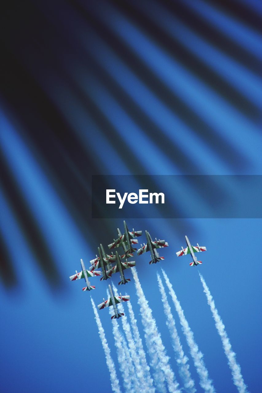 Low angle view of airplane flying against clear blue sky