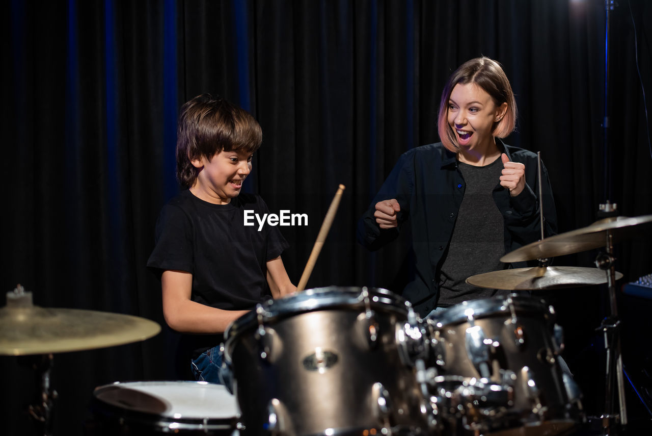 Teacher teaching drumming to boy