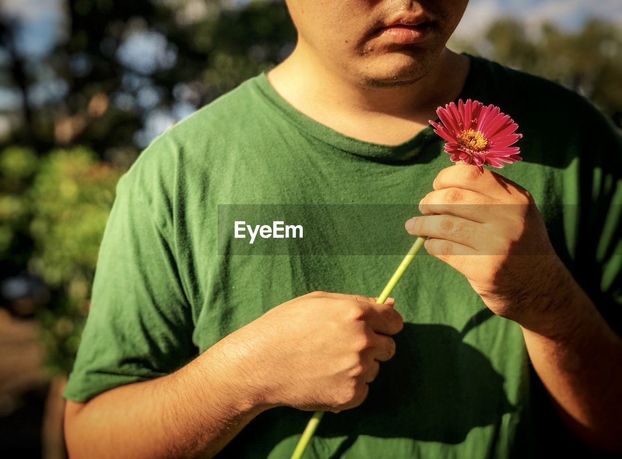 MIDSECTION OF MAN HOLDING FLOWER