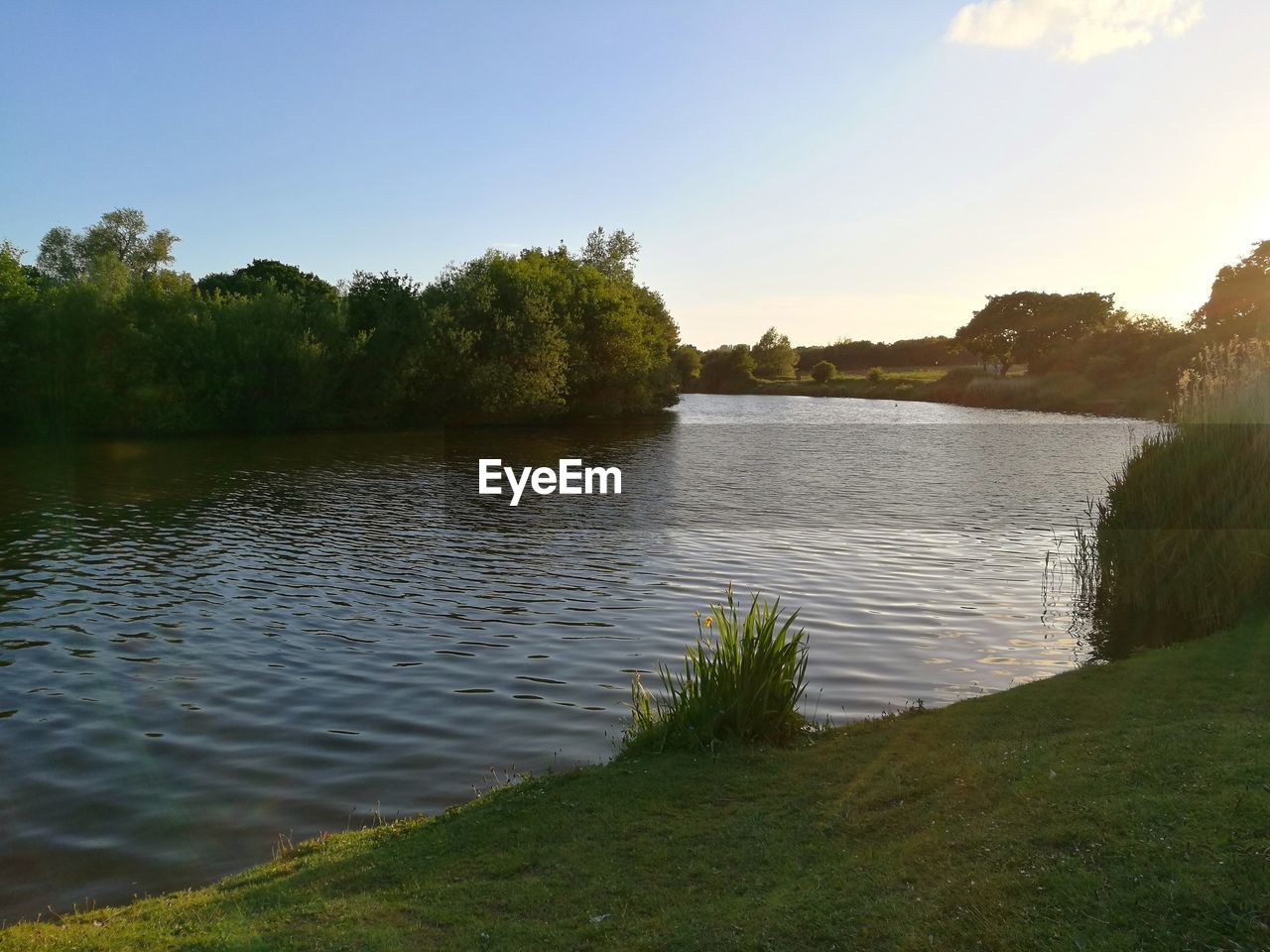 SCENIC VIEW OF LAKE AGAINST SKY AT SUNSET