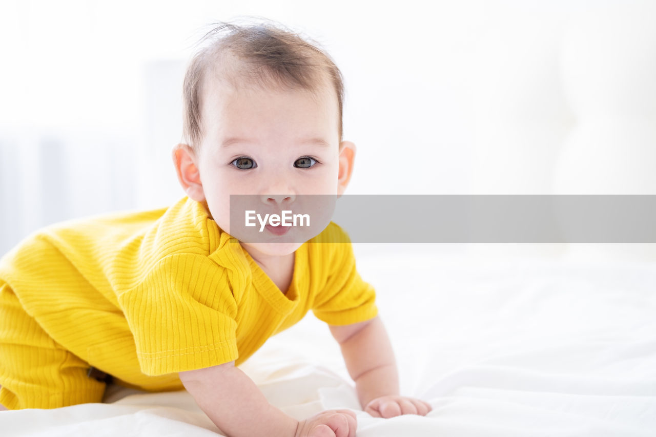 portrait of cute baby boy lying on bed