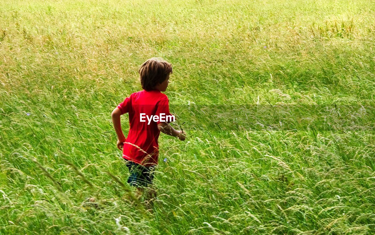 High angle view of boy running on grassy field