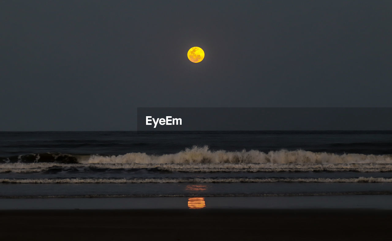 Scenic view of sea against clear sky at night