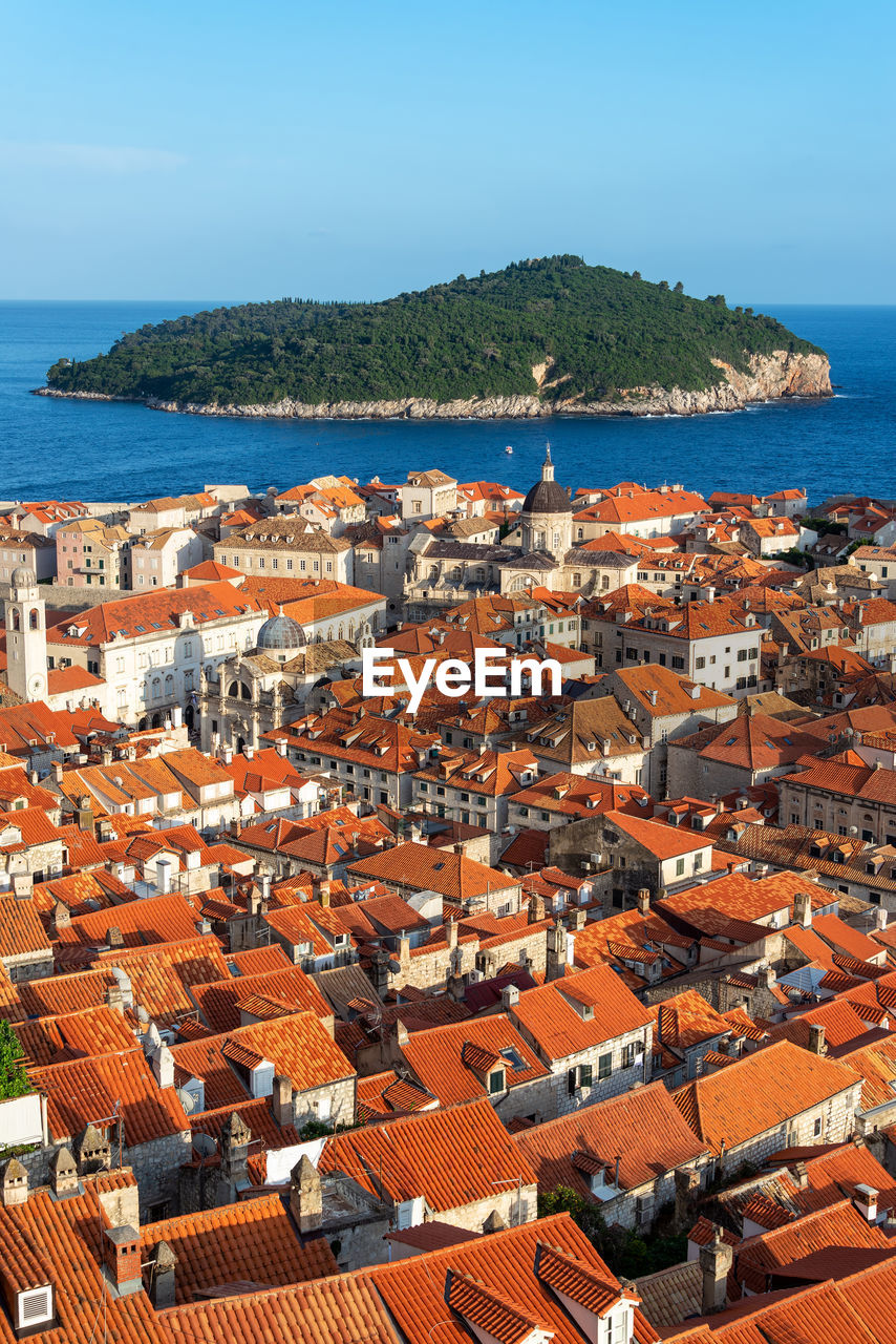 High angle view of townscape by sea against clear sky