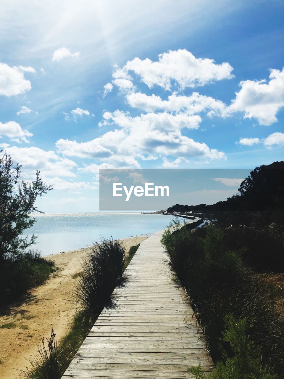 Footpath by sea against sky