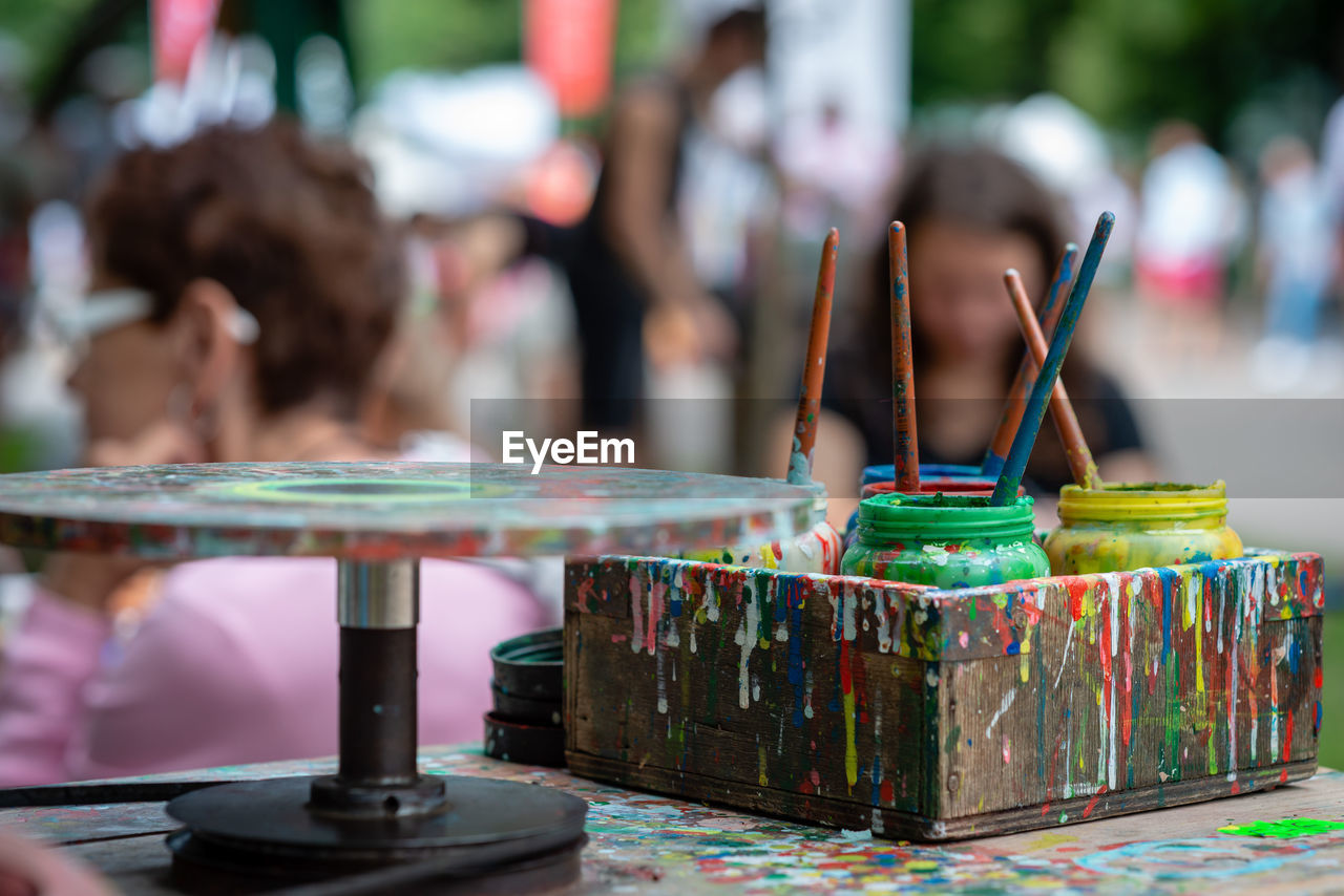 Close-up of multi colored paints containers on table