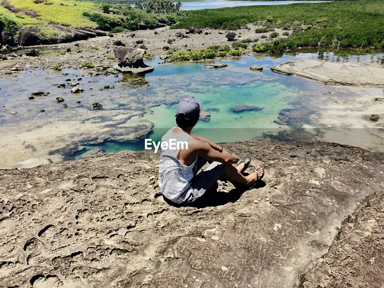 Man relaxing by lake on sunny day
