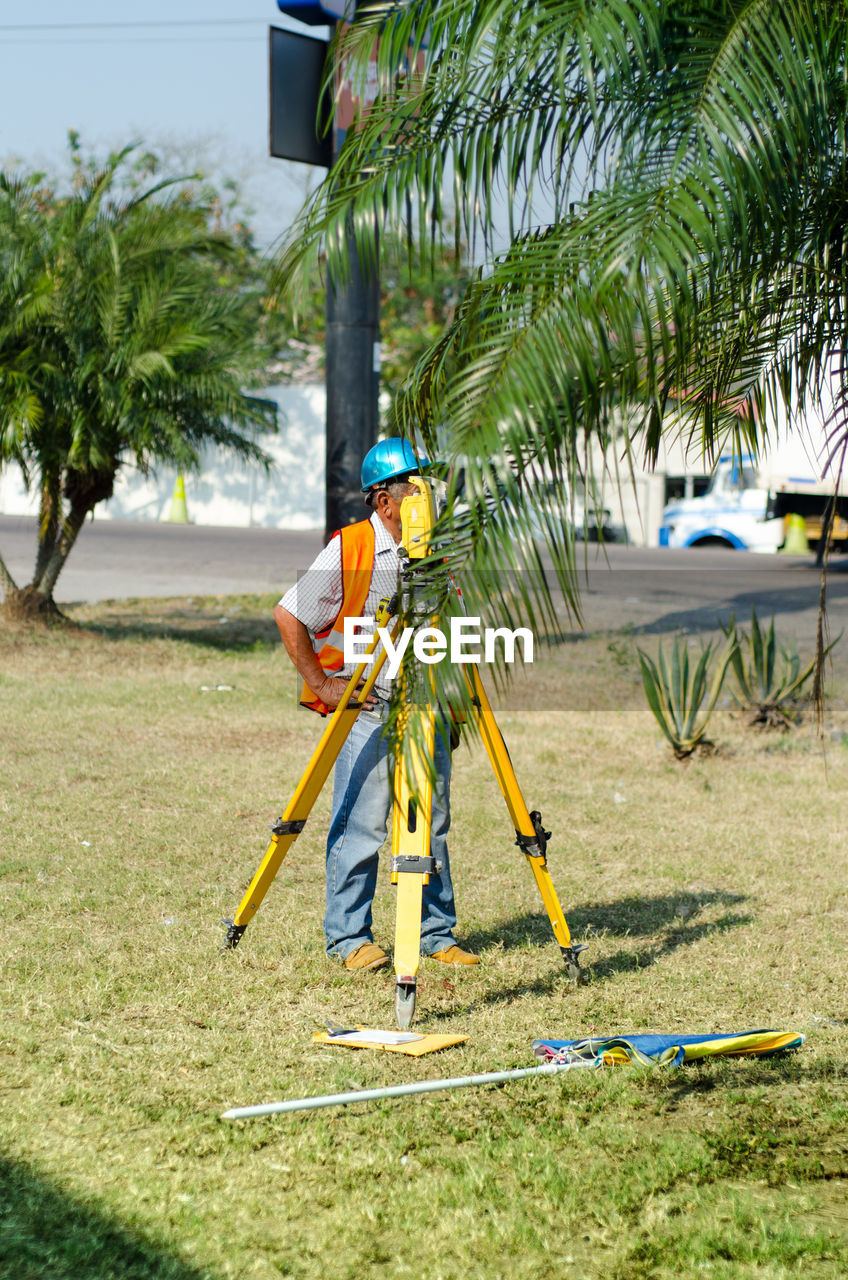 Engineer using equipment while standing on grass